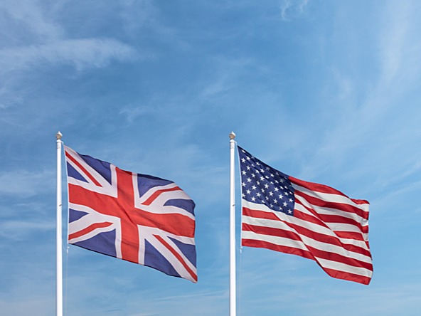 UK and US flags against a blue sky 